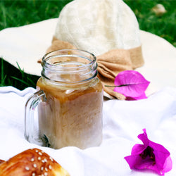 café sin nombre con leche de soya frio con un sombrero de fondo y un pan