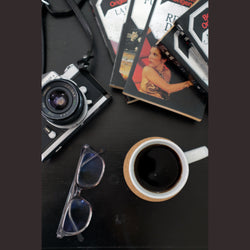 taza de café sin nombre libros de colección, cámara réflex antigua nikkormat ftn1 y lentes